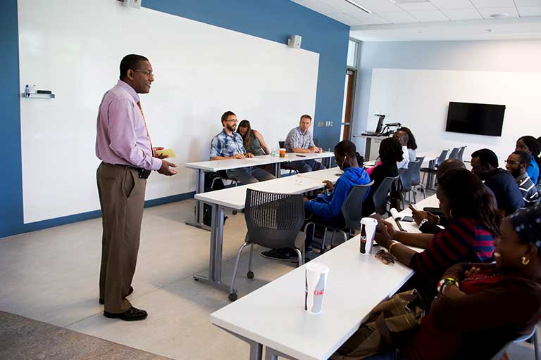 A faculty member lectures in front of a class.