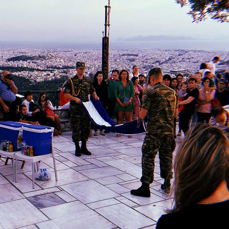 An audience watches as two soldiers fold a flag.