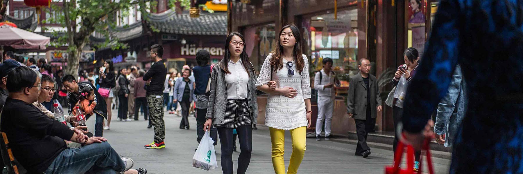 Two people link arms as they walk down the street in China.