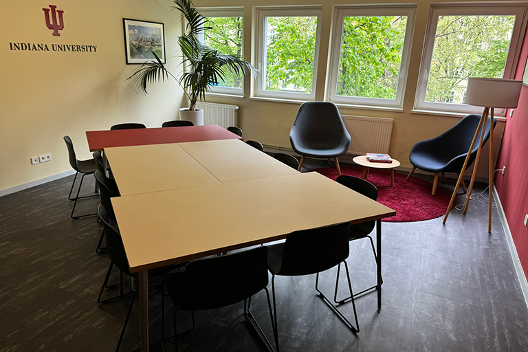 IU Europe Gateway lobby featuring a large roundtable, with 4 individual tables and 12 chairs
